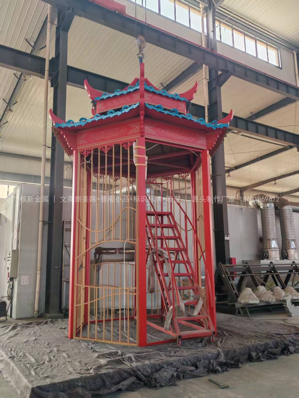 辽宁仿古演绎舞台双层塔式金属构件在车间组装，宝蓝色琉璃瓦顶与红色框架
