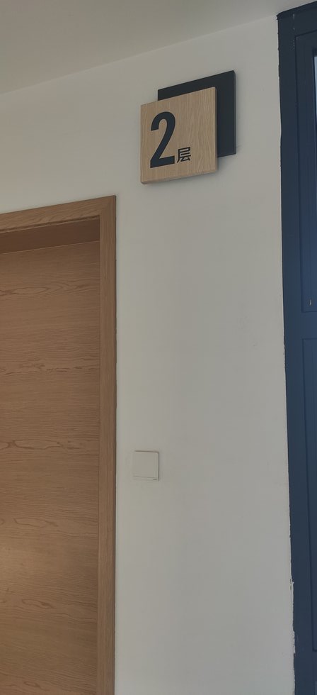 照金干部学院项目楼层牌成品实拍,黑色底板与浅木纹面板叠层结构