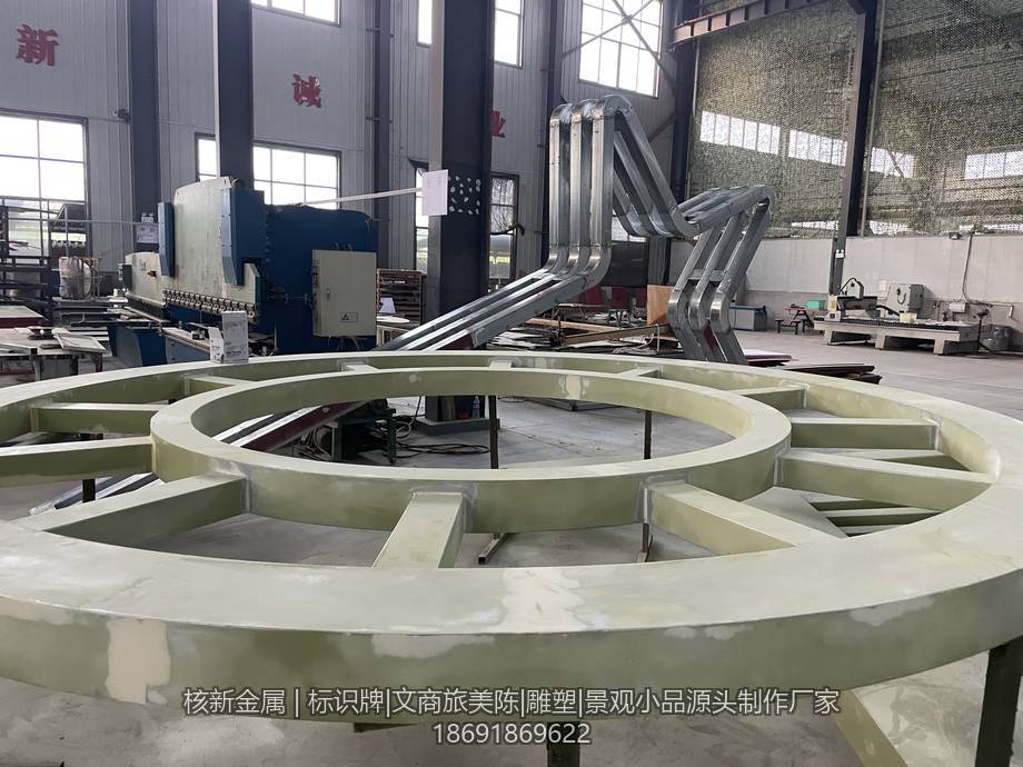 工厂车间内大型金属美陈装置的雕塑骨架,方管与钢板焊接成型后尚未蒙皮