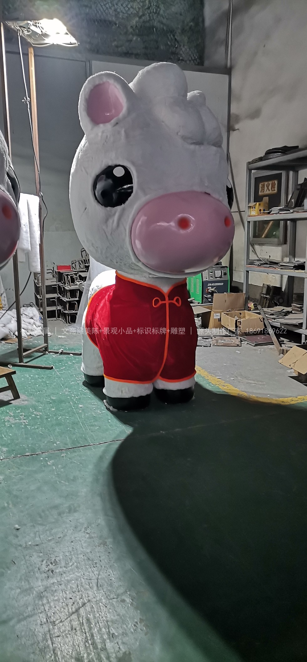 雕塑车间内已完成表面处理的卡通马雕塑,白色主体配红色装饰件,等待试拼核对
