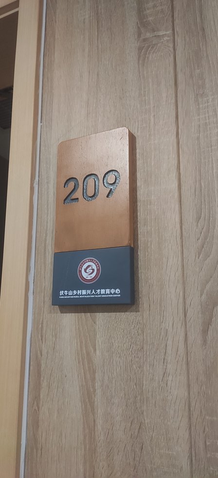 洛阳栾川伏牛山党校房间门牌实拍,209数字为立体凸起,配深色铭牌印有教育中心名称与英文名称